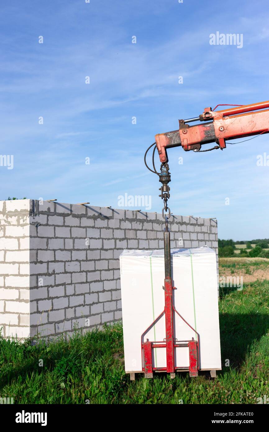 Unloading building blocks from a truck using a crane. Hydraulic ...