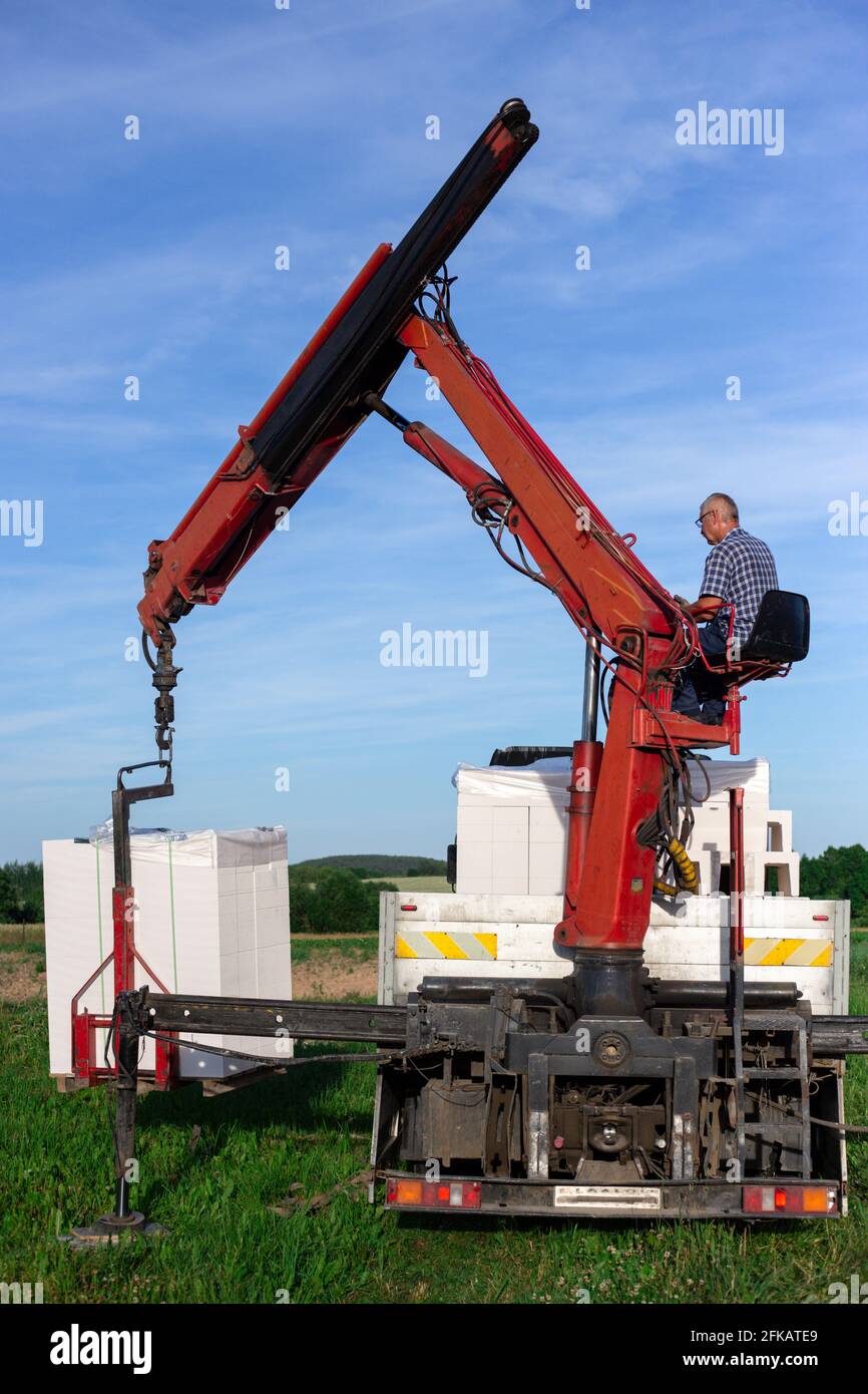 Unloading building blocks from a truck using a crane. Hydraulic ...