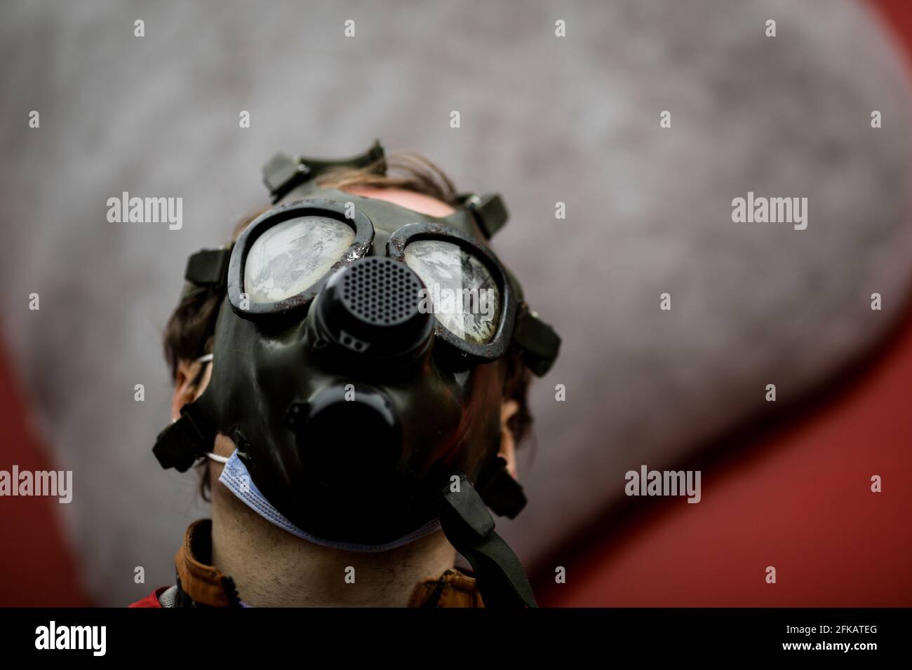 Shallow depth of field (selective focus) image with an old and worn out military gas mask without filters on the face of a man. Stock Photo