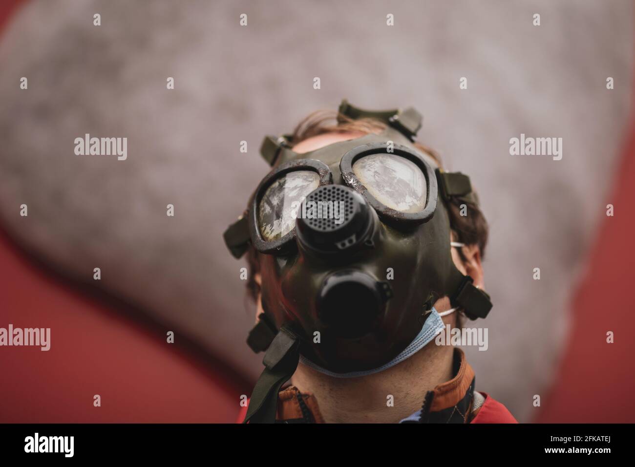 Shallow depth of field (selective focus) image with an old and worn out military gas mask without filters on the face of a man. Stock Photo