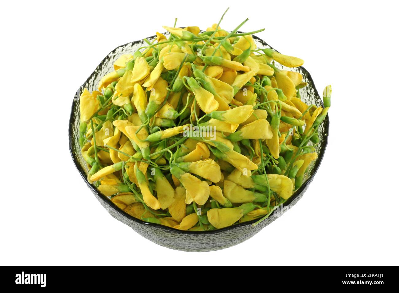A bowl of freshly picked Sesbania Blossoms. These yellow flowers are eaten as a vegetable in Southeast Asia Stock Photo