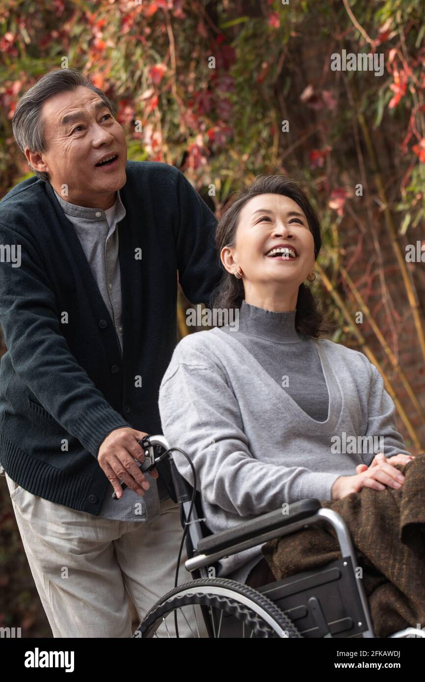 The old man pushed the wheelchair's wife Stock Photo