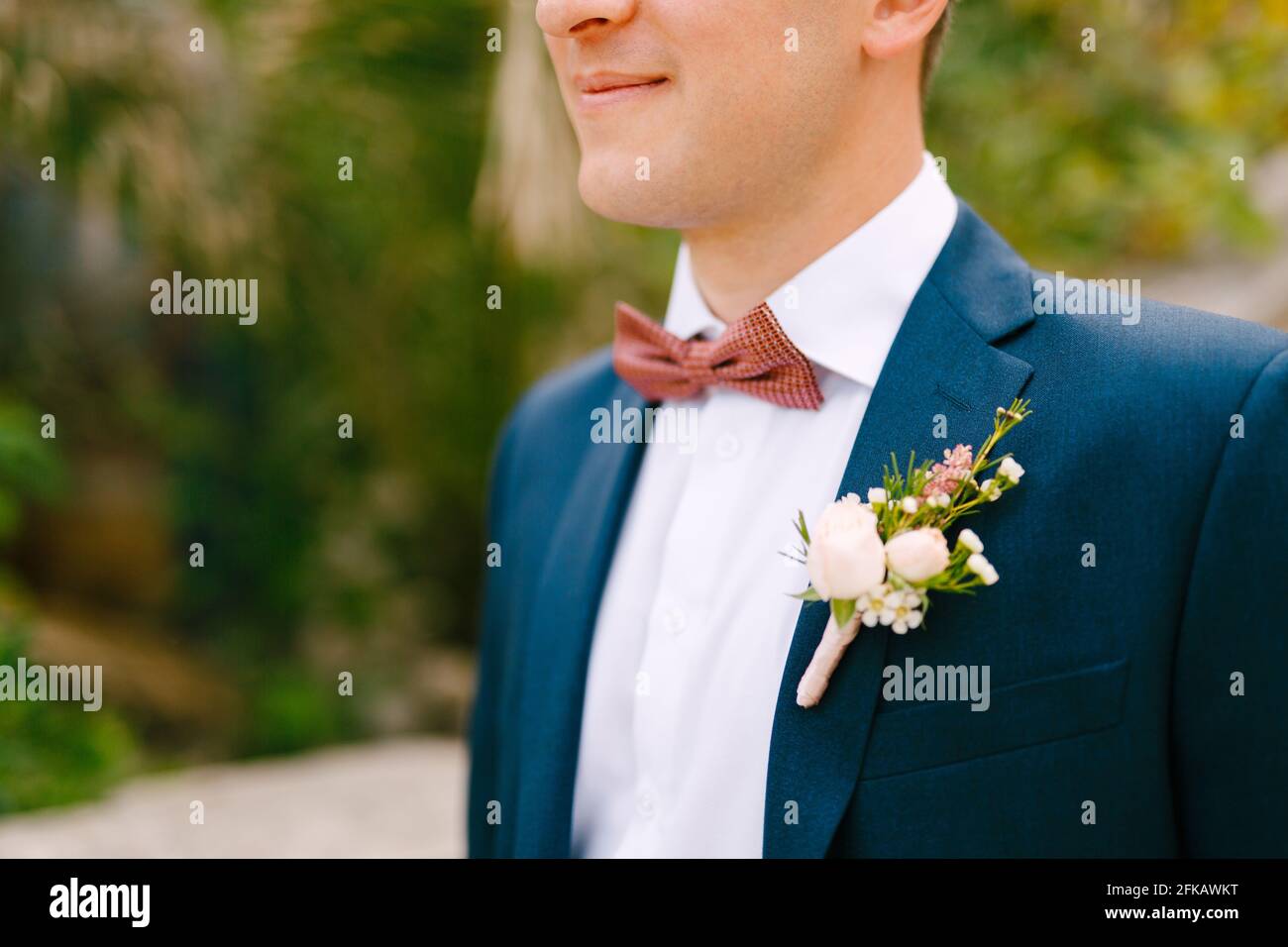 A man in a blue jacket, white shirt, burgundy bow tie and with a ...