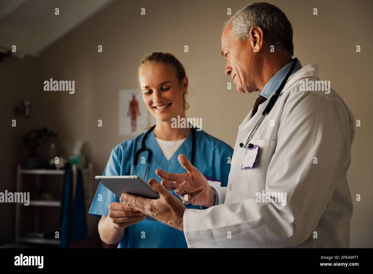 Male and female doctors smiling looking at positive results on digital tablet. Stock Photo