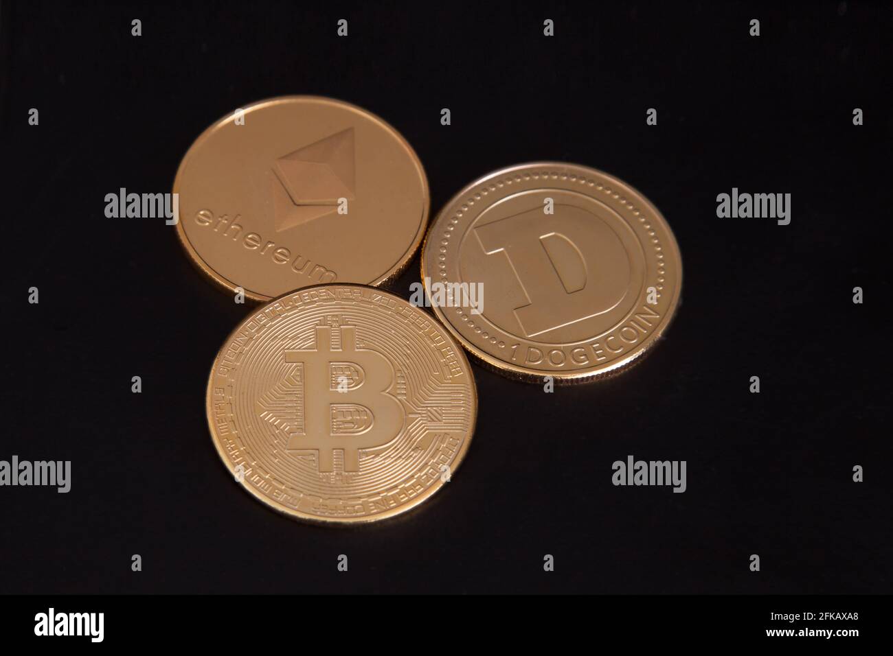 Three crypto gold coins, Bitcoin, Ethereum, Dogecoin, BTC ETH DOGE, physical cryptocurrency, trading crypto coins Stock Photo