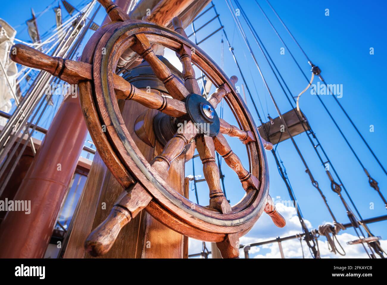 steering wheel of a sailboat against a blue sky Stock Photo Alamy