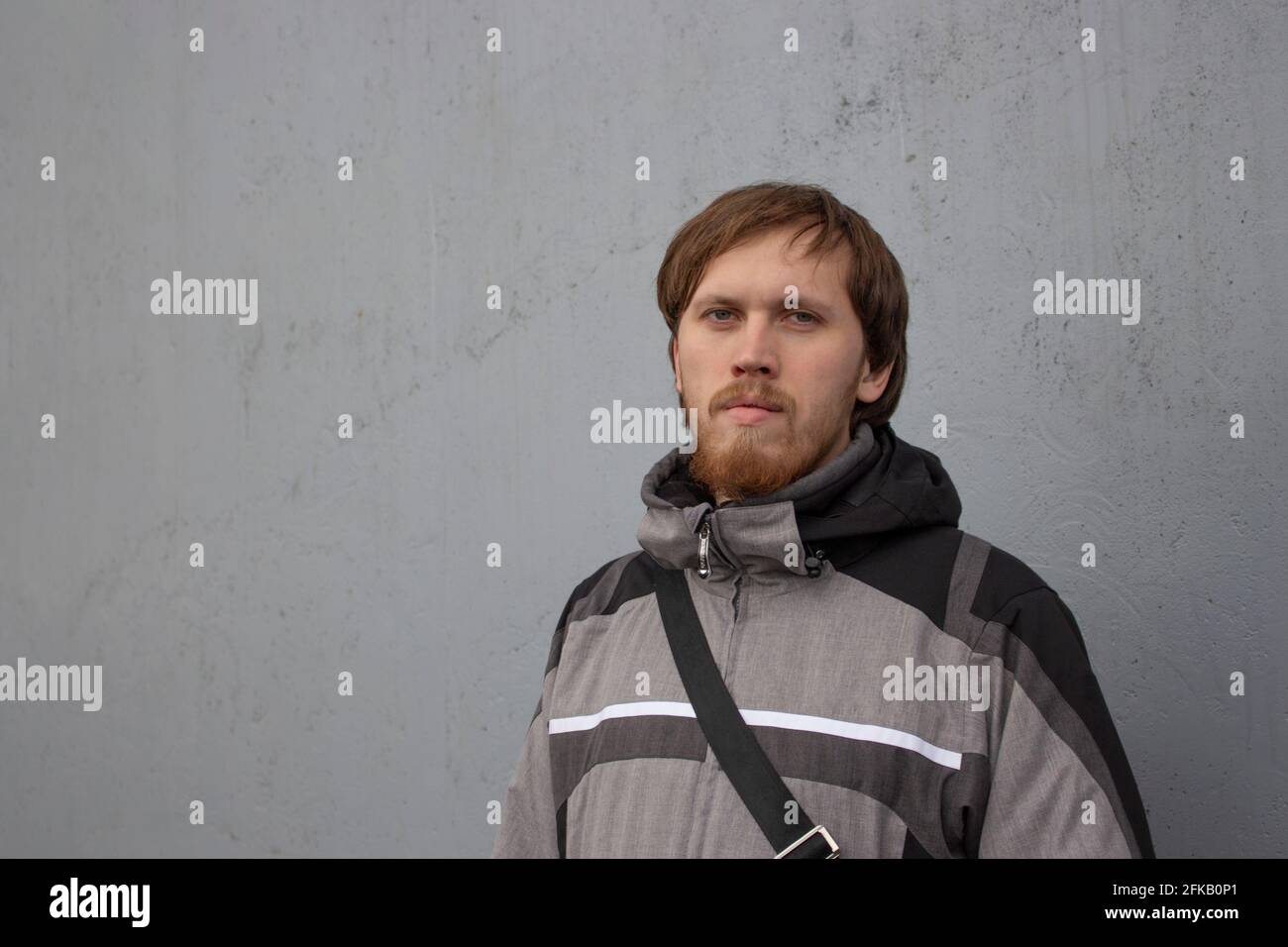 Young Caucasian male 30 years old in a gray jacket. Mujina with a beard ...