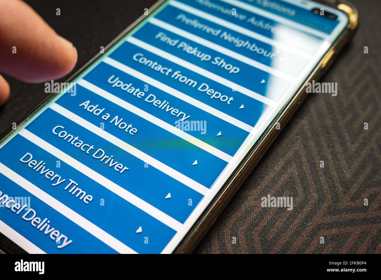 Male thumb finger over parcel delivery app on smartphone screen Stock ...