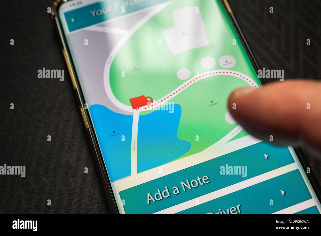 Male thumb finger over parcel delivery app on smartphone screen Stock ...