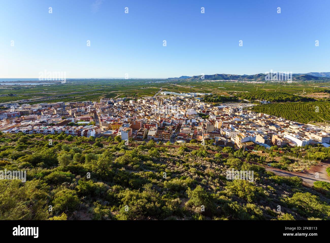 Panoramic view of a town surrounded by green vegetation Stock Photo