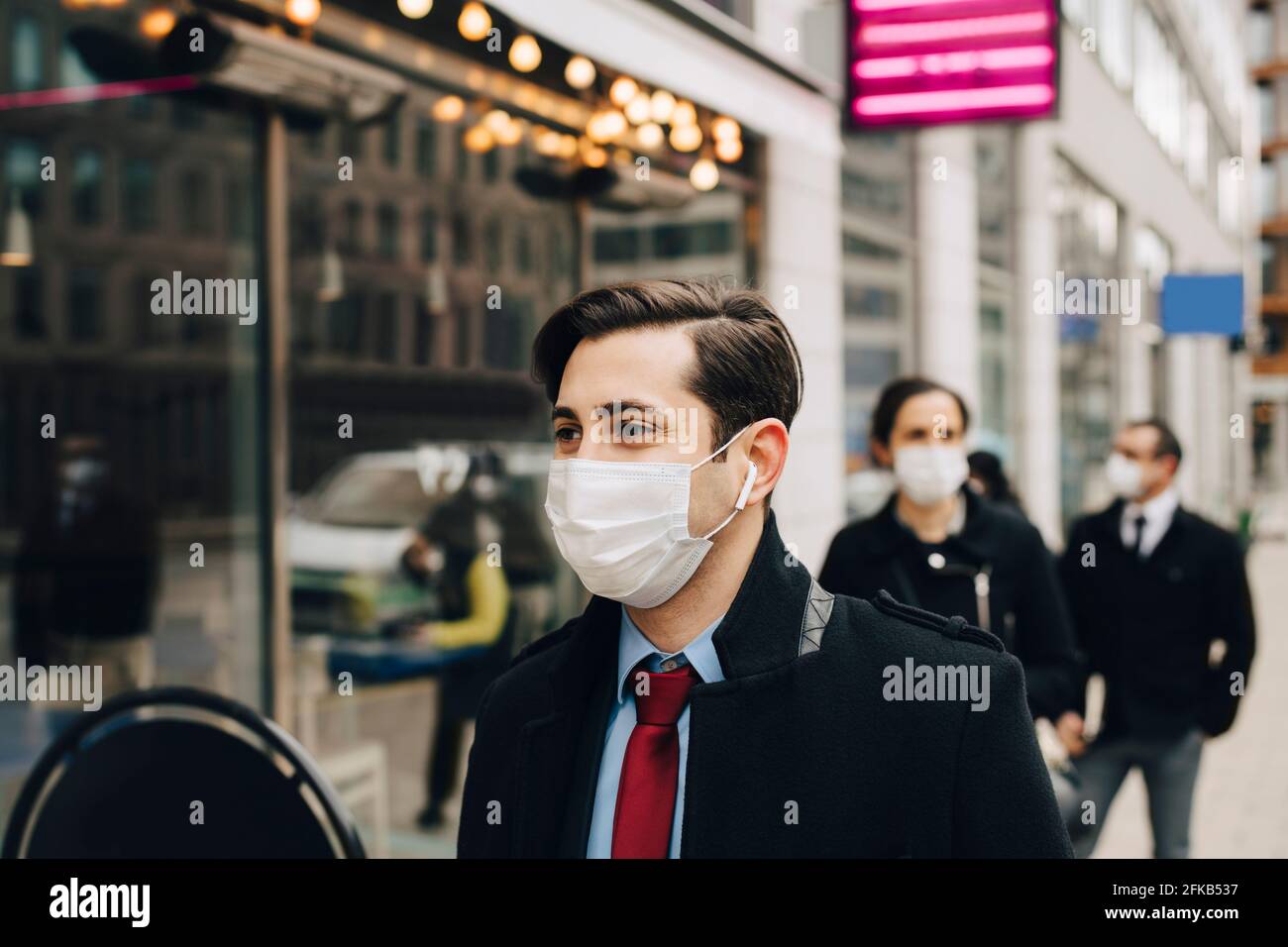 Business people standing in line outside store during pandemic Stock Photo