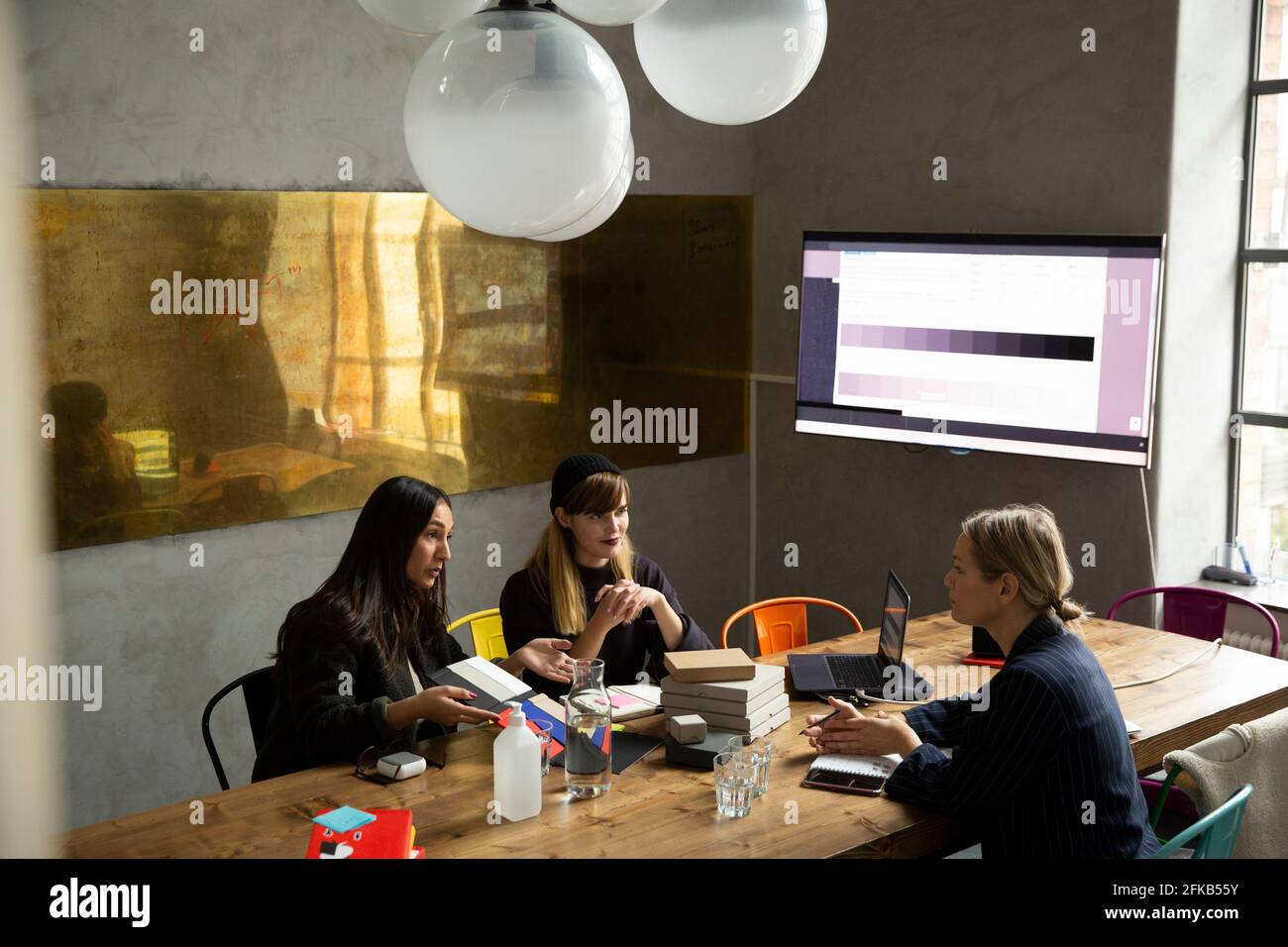Businesswoman with female colleagues discussing over color swatch in conference room Stock Photo