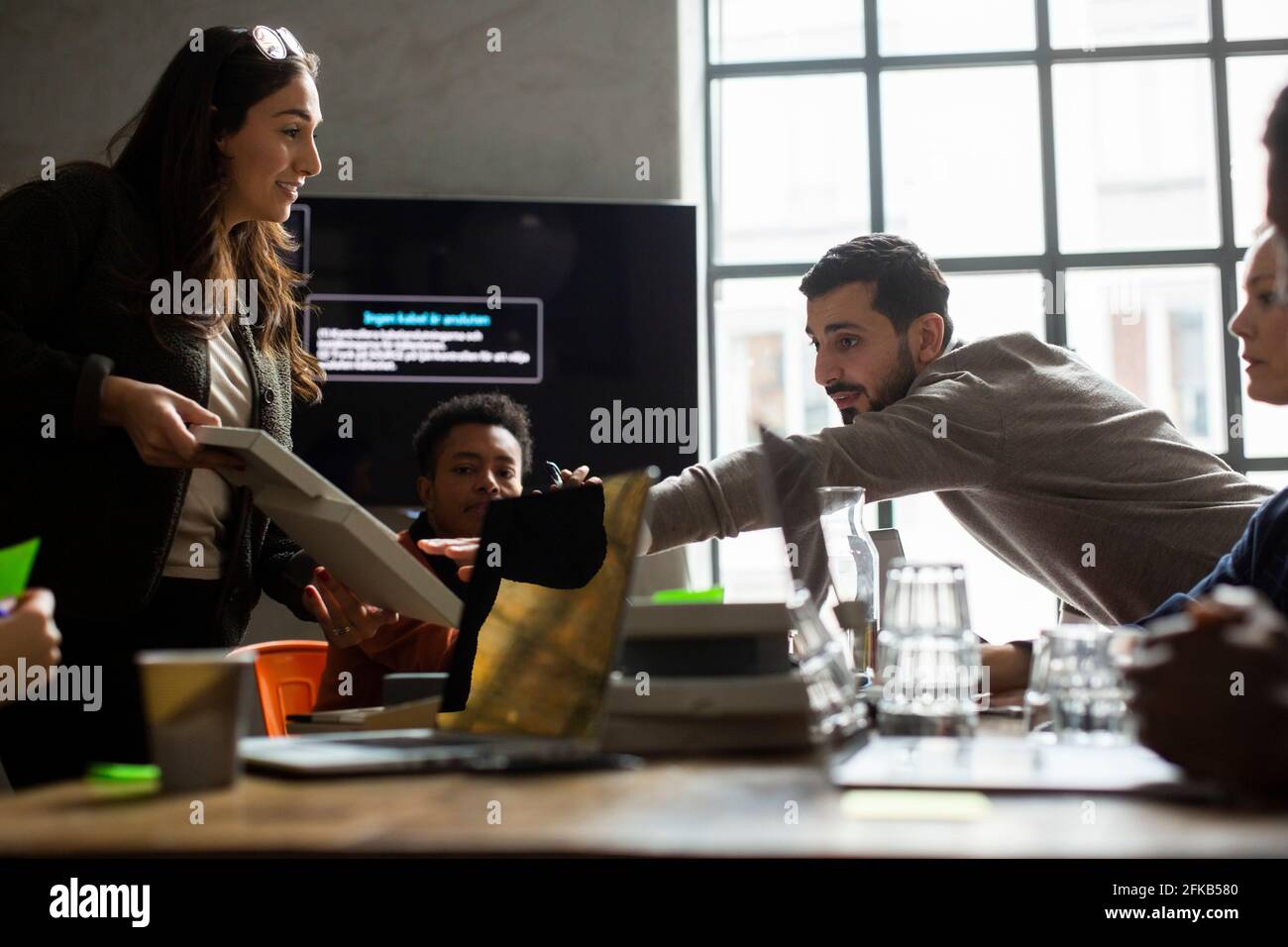 Male and female entrepreneurs discussing over product at creative office Stock Photo