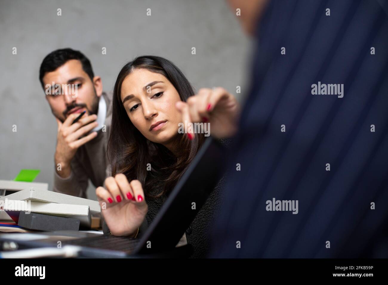 Male and female entrepreneurs discussing over laptop at office Stock Photo
