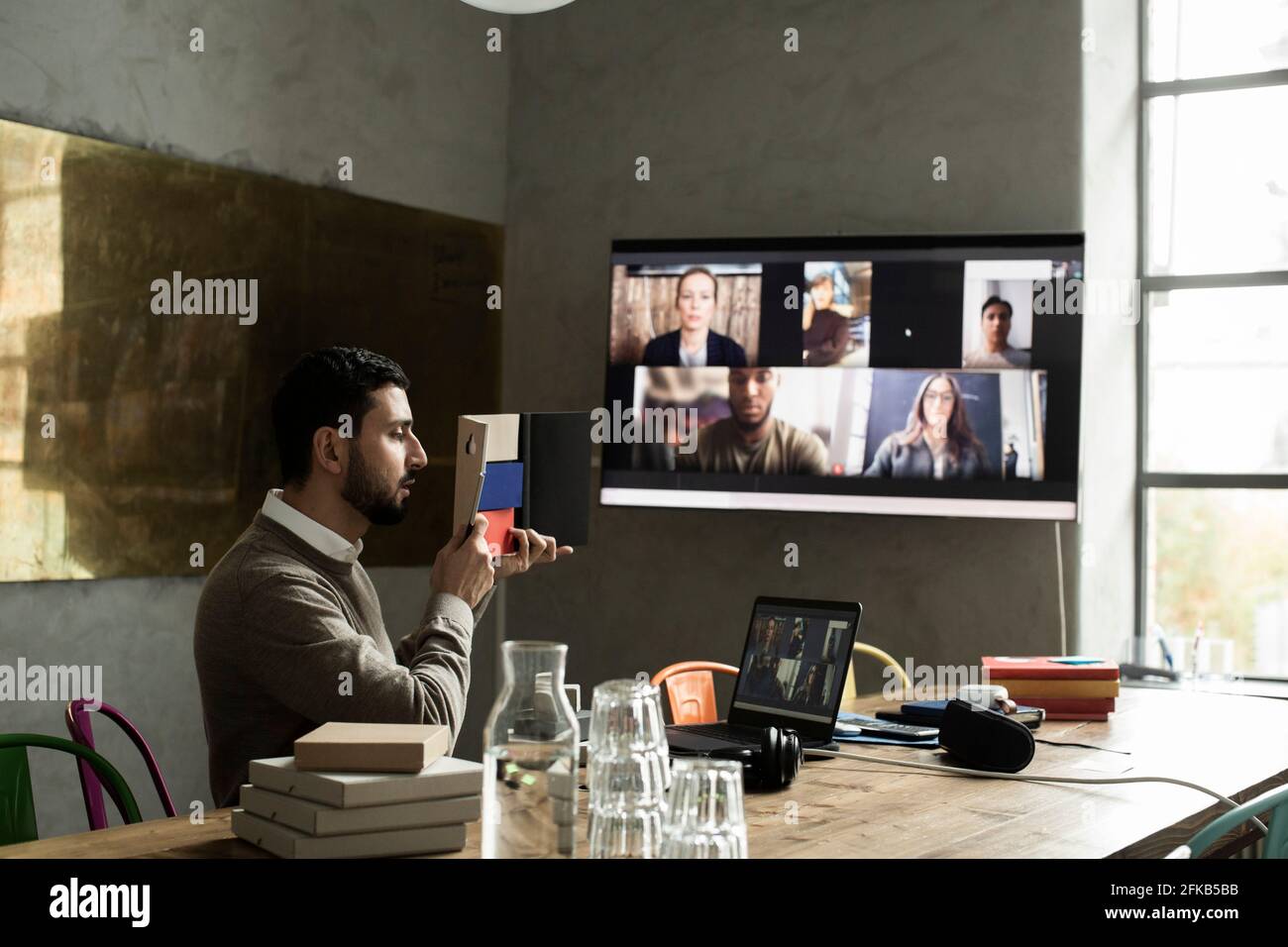 Male entrepreneur reading diary during meeting on video conference in creative office Stock Photo