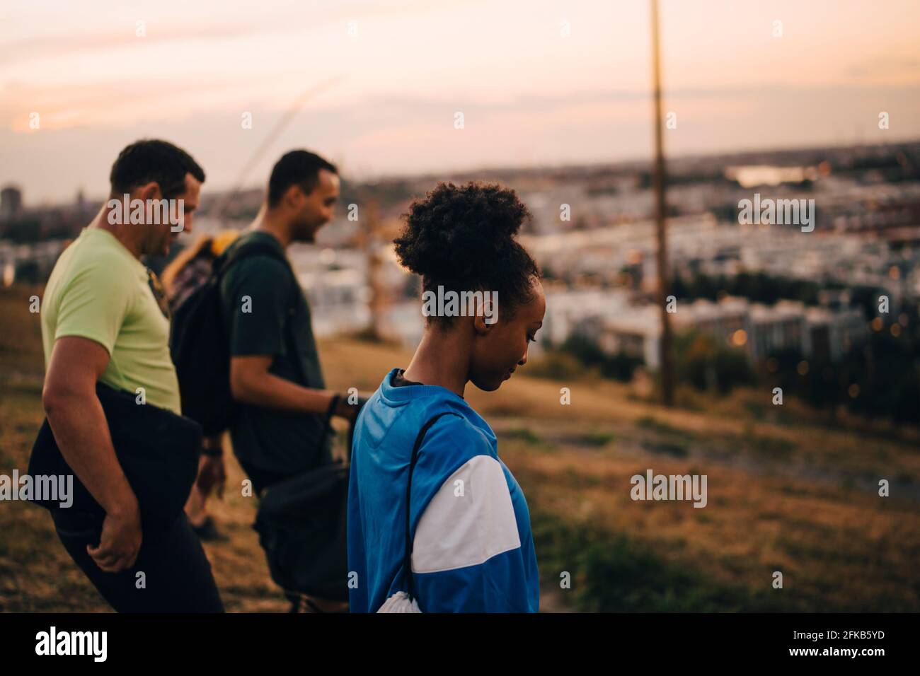 Male and female athletes standing on land during sunset Stock Photo