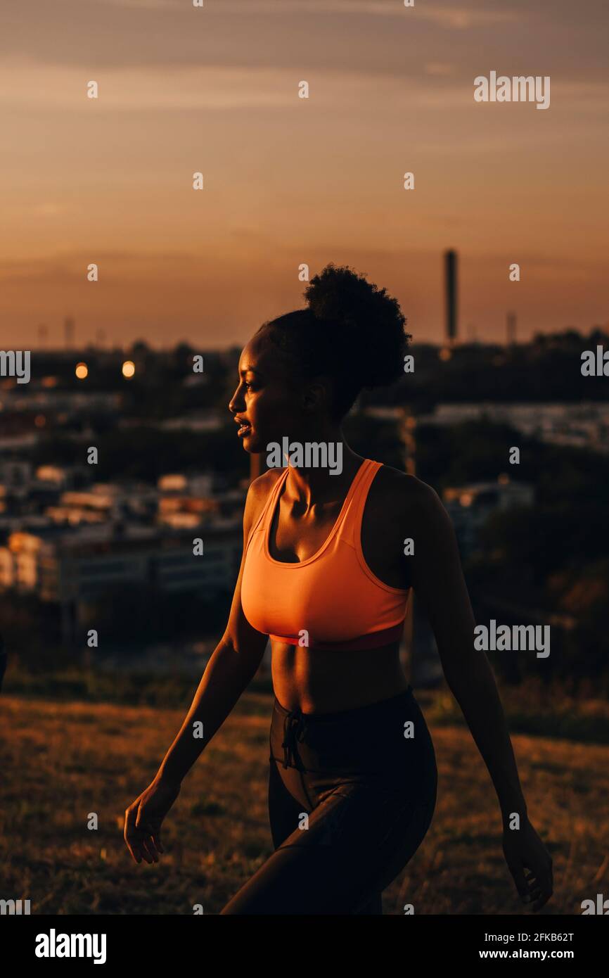 Female athlete looking away during sunset Stock Photo