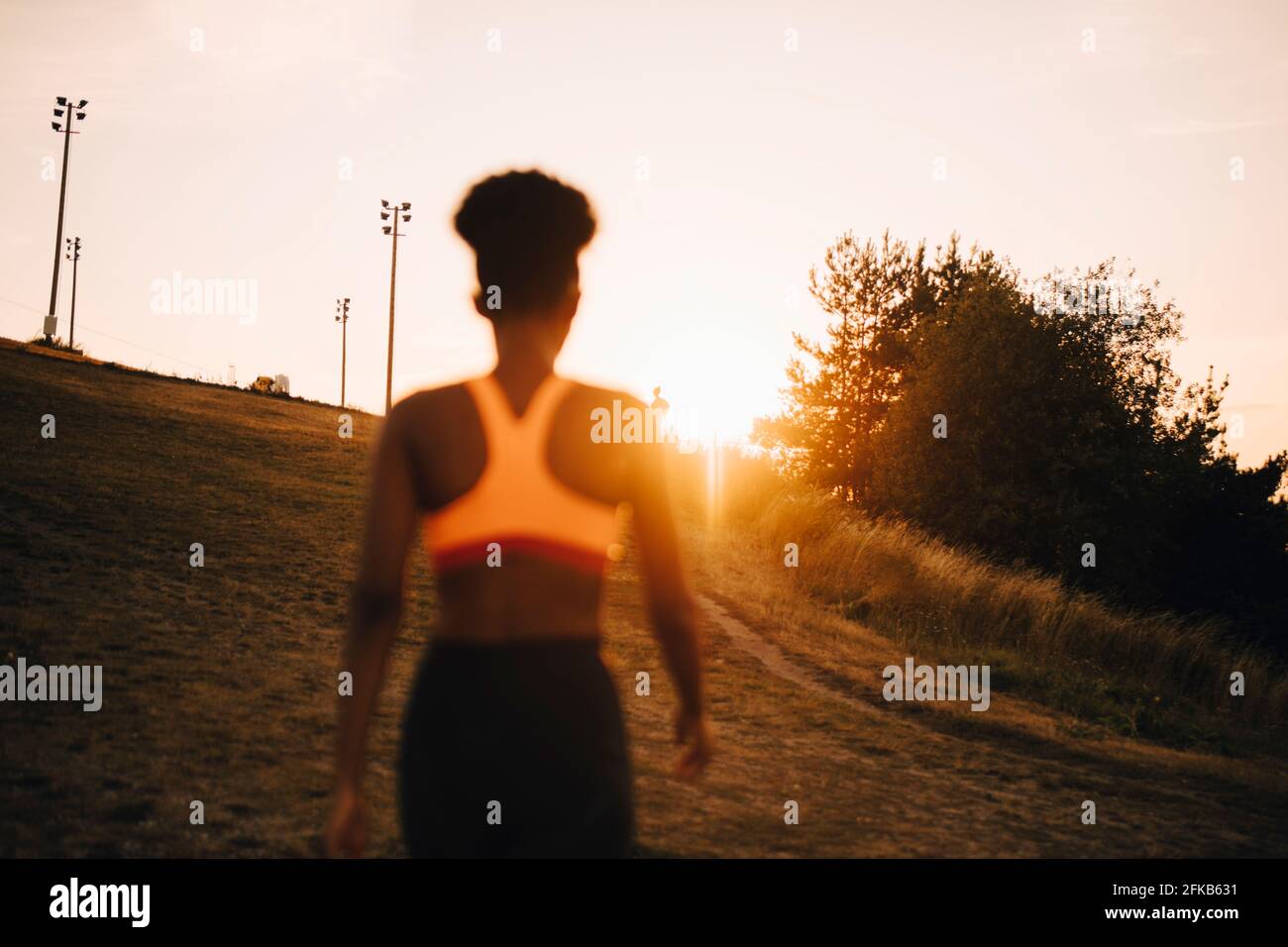 Rear view female athlete looking at sunset Stock Photo