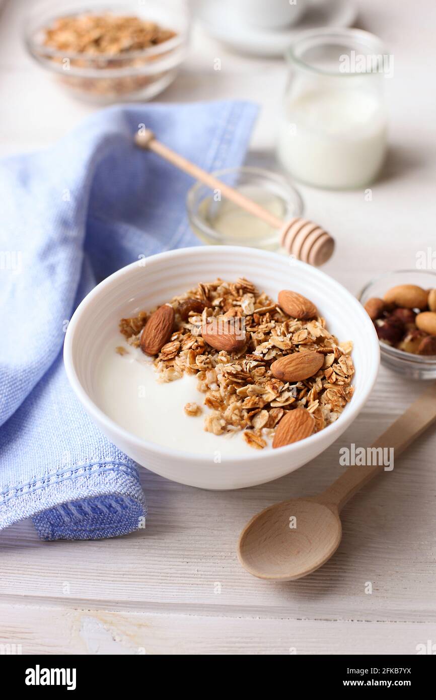 Healthy breakfast. Yogurt with granola and nuts on window sill Stock Photo