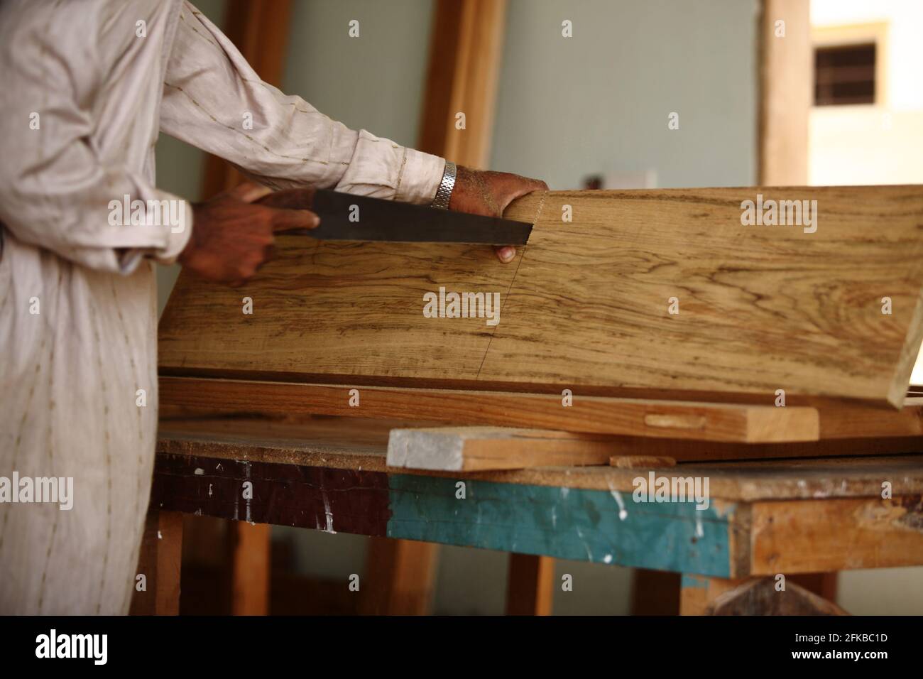 Carpenter is making a panel door frame of teak wood in a room of under