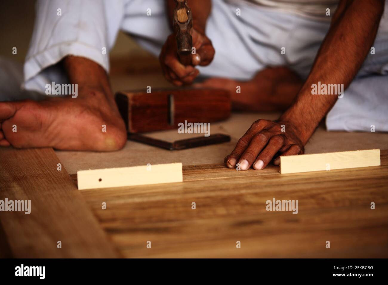 Royalty free photo of carpenter making modern Teak Wood pasted panel door. Stock Photo