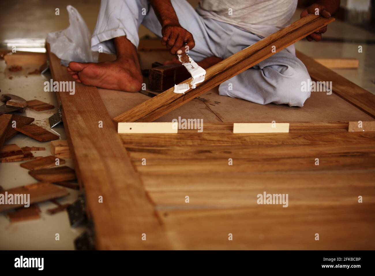 Royalty free photo of carpenter making modern Teak Wood pasted panel door. Stock Photo