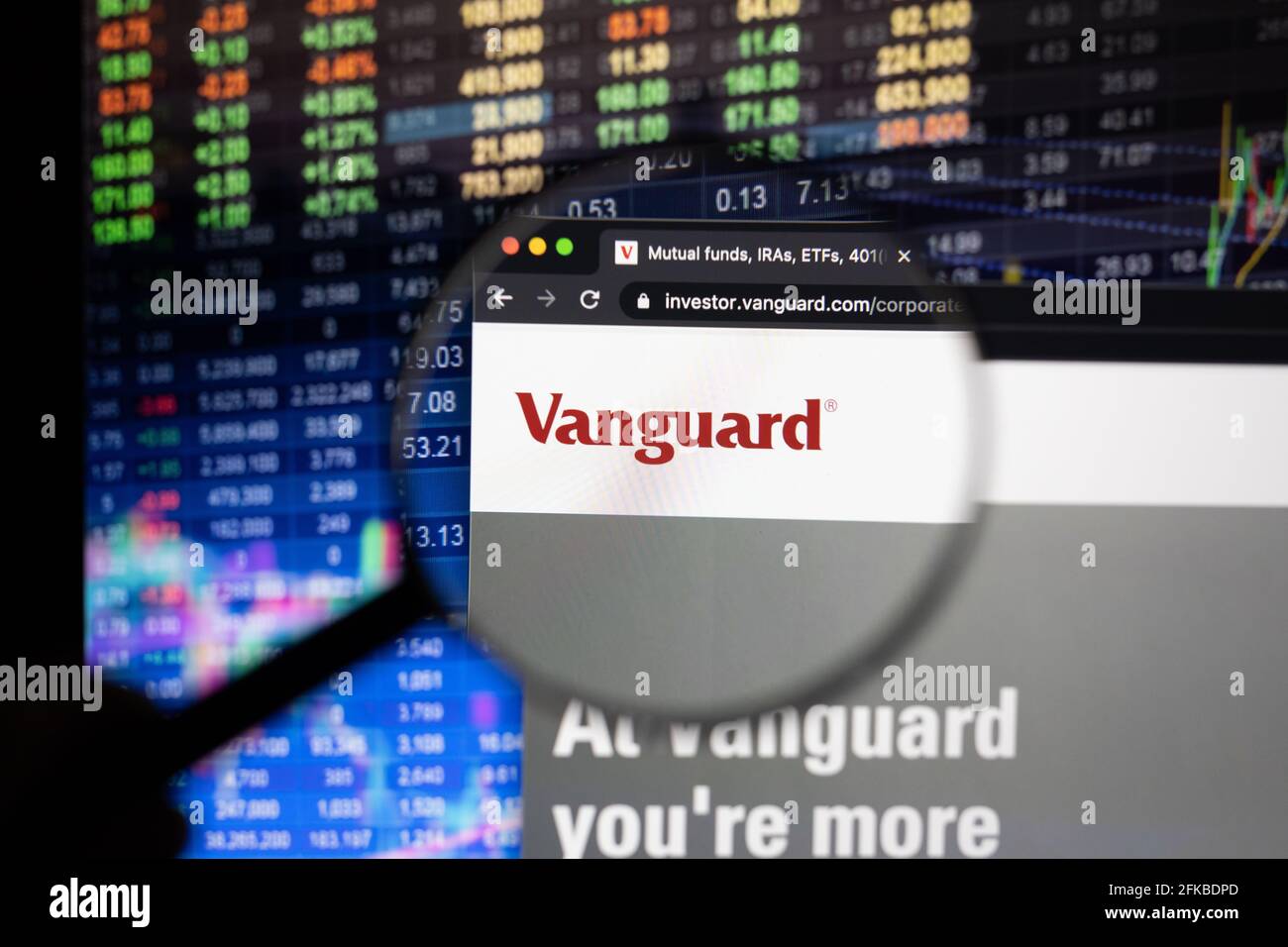 Vanguard company logo on a website with blurry stock market developments in the background, seen on a computer screen through a magnifying glass Stock Photo