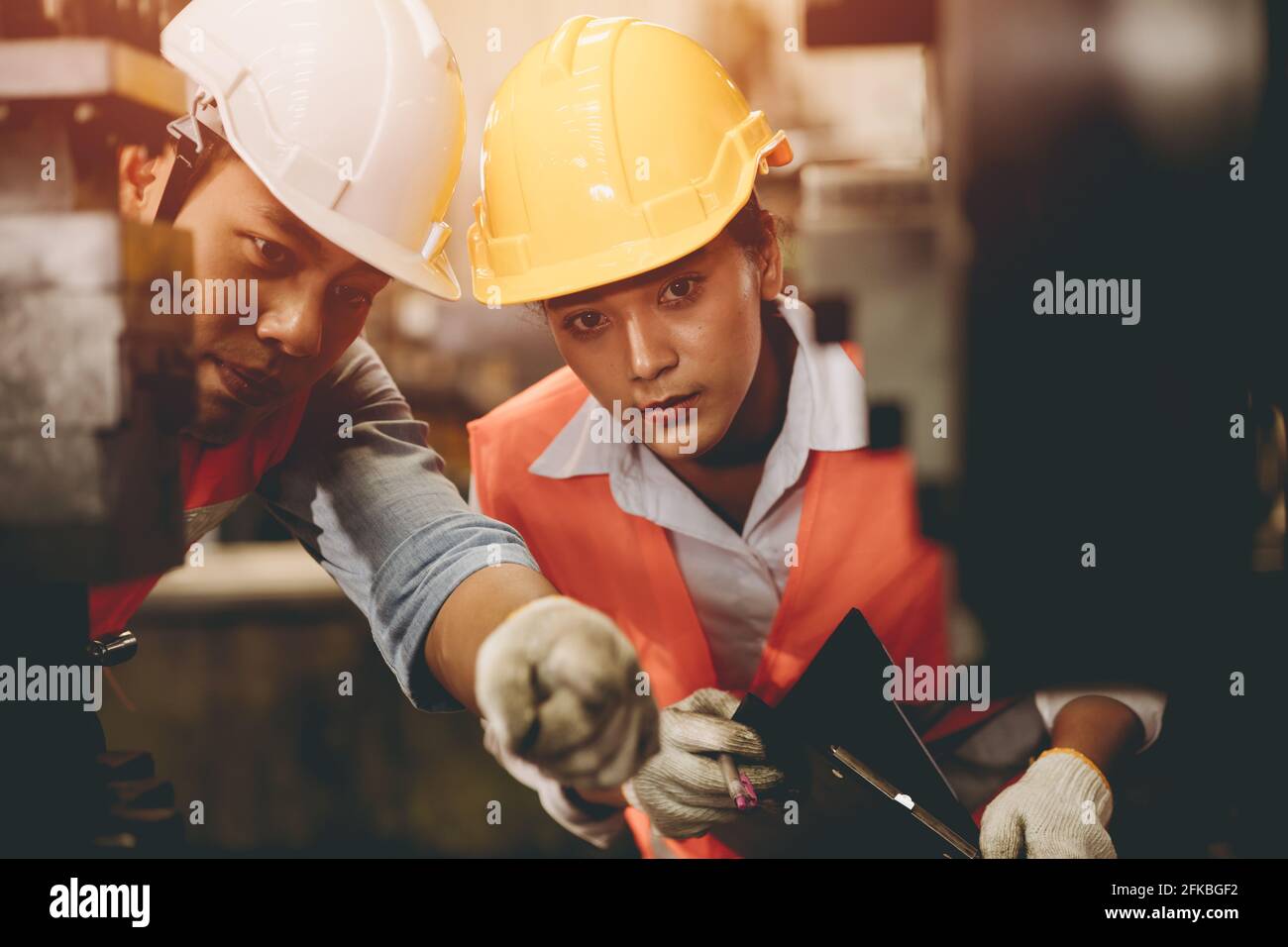 Engineer team male working with women work help support together in heavy industry teach and training machine operation in factory Stock Photo