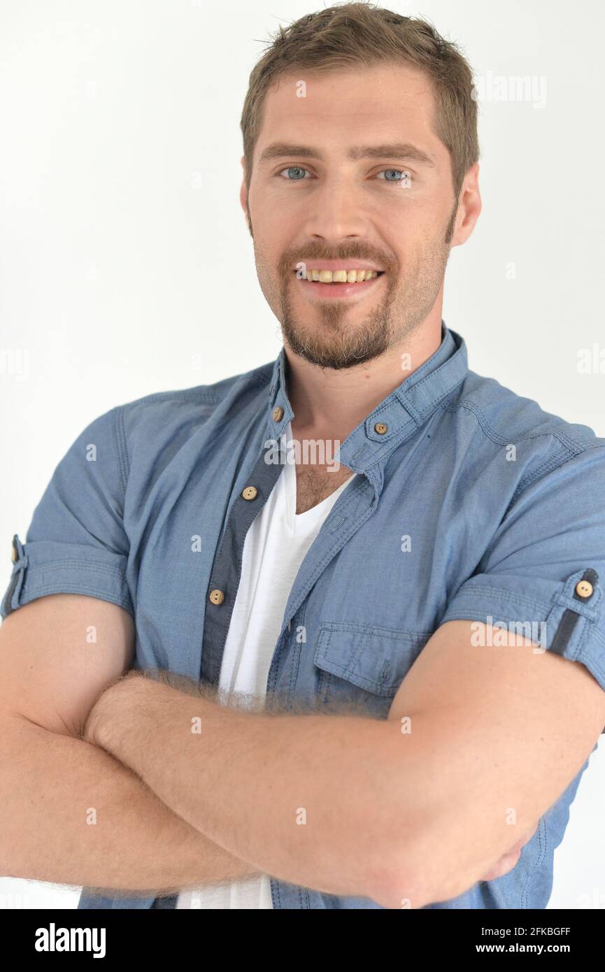 Handsome young man with arms crossed posing in studio Stock Photo - Alamy
