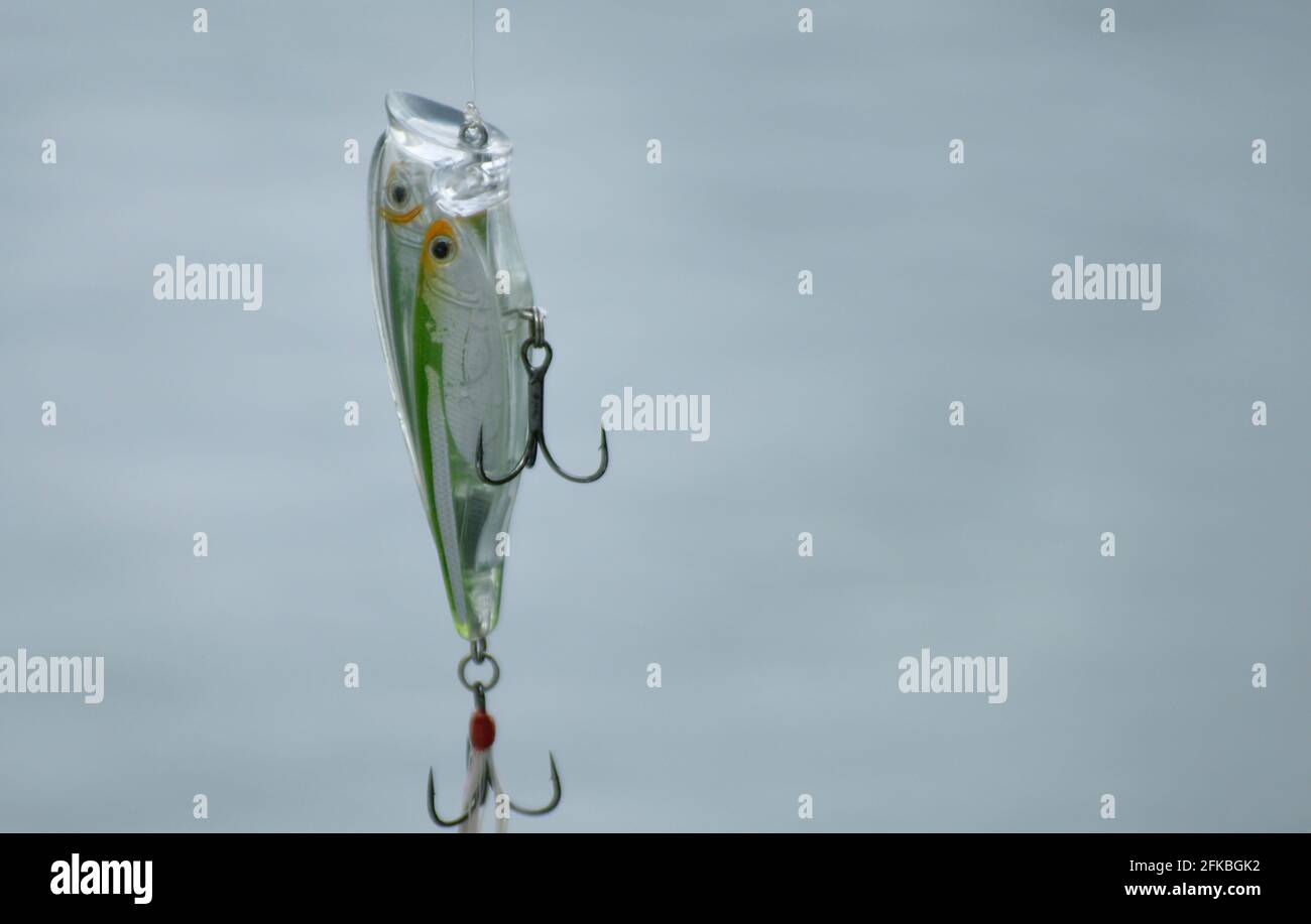 A fishing lure is hung with fishing line or wire ready to be cast into the  water Stock Photo - Alamy