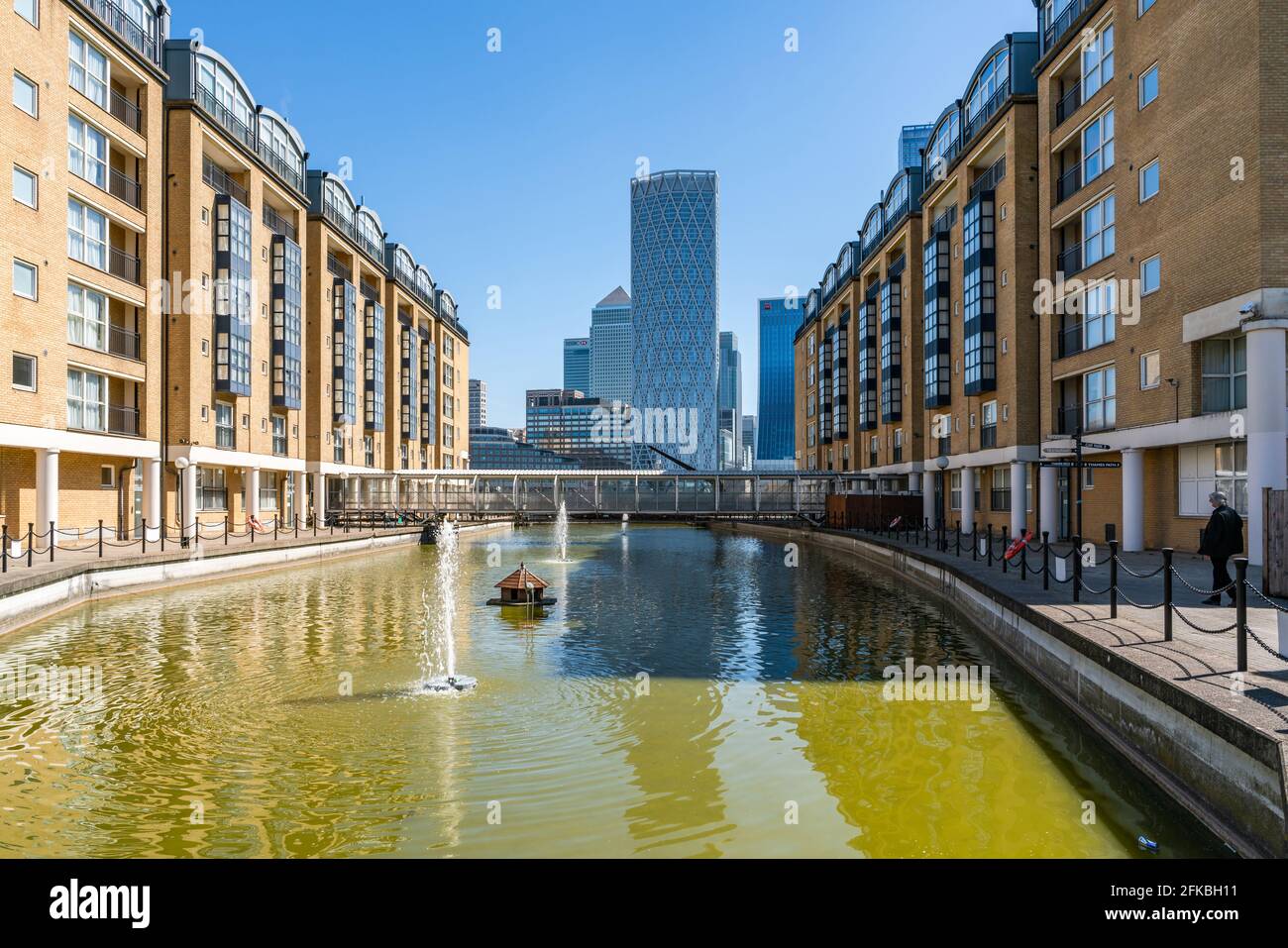 LONDON, UK - APRIL 23, 2021: Modern skyscrapers of Canary Wharf, the financial hub in London seen across the Old Nelson Dock Stock Photo