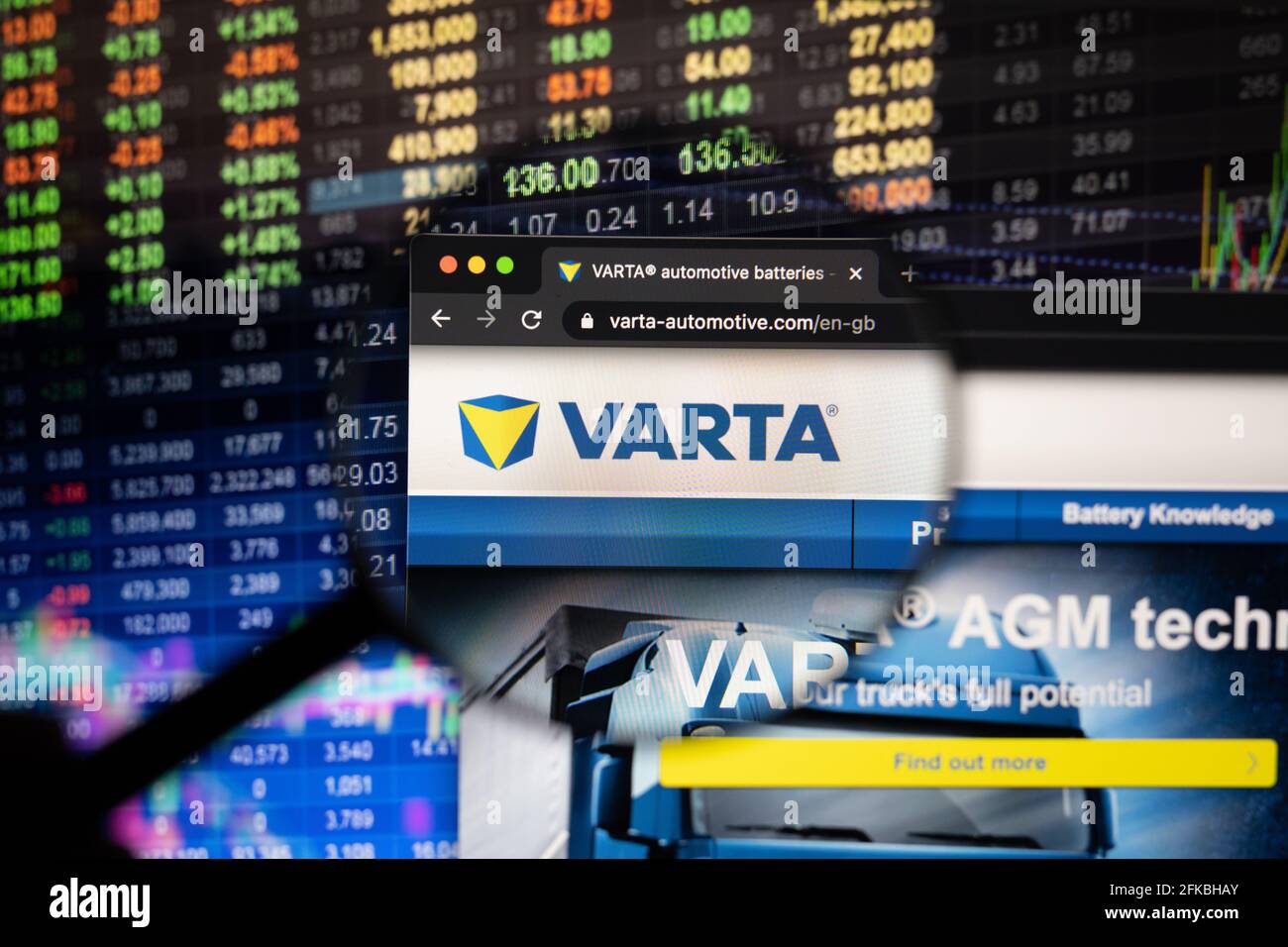 Varta company logo on a website with blurry stock market developments the background, seen on a screen through a magnifying glass Stock Photo