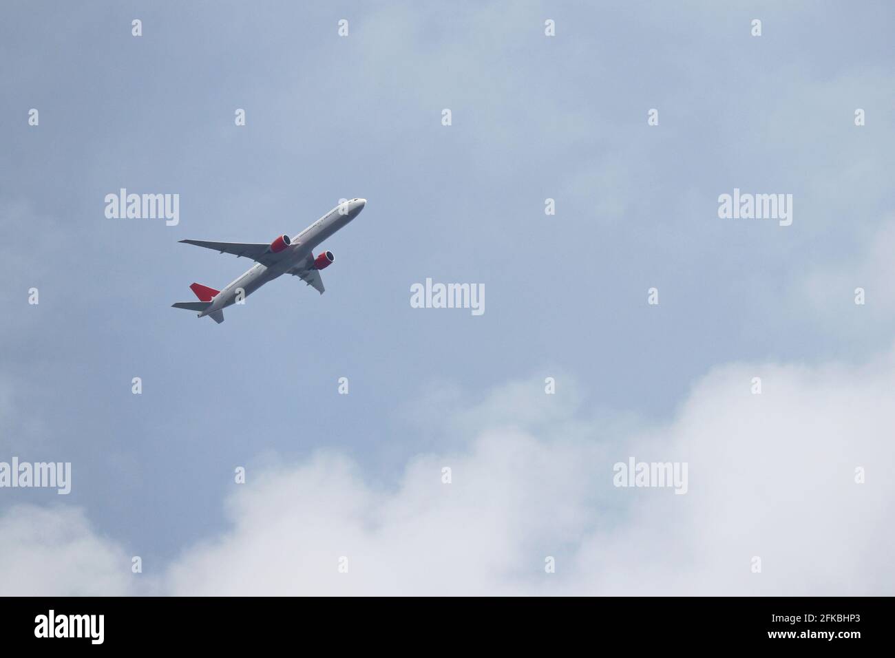 Airplane flying in the blue sky with white clouds. Passenger plane at ...