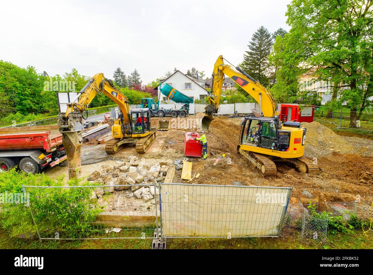 Destruction of the old house in order to build a new one. Heavy bulldozer tearing down a villa and frees up space for a new building. Riehen, Switzerl Stock Photo