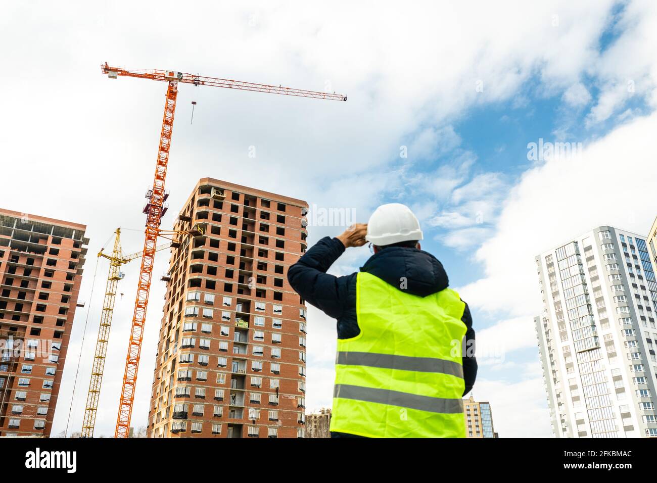 Consulting engineer at construction site holding blueprint in hand