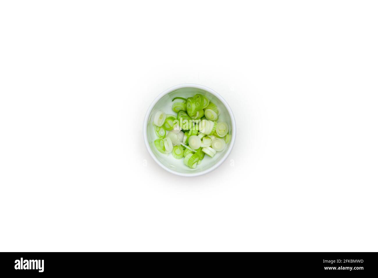 Chopped Spring Onions in Small White Dish on White Background Stock Photo