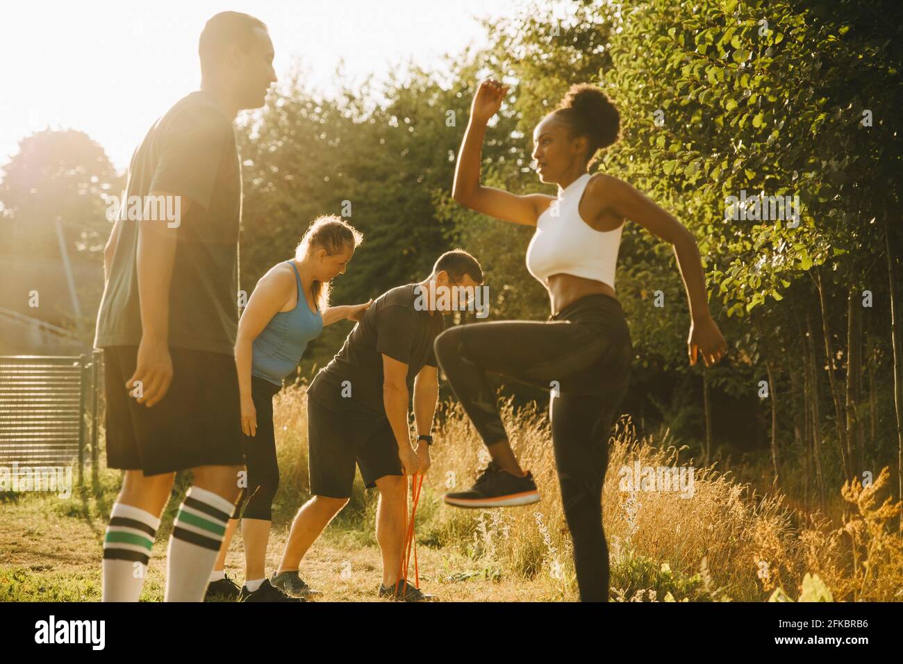 Male and female athletes practicing sports training in park Stock Photo