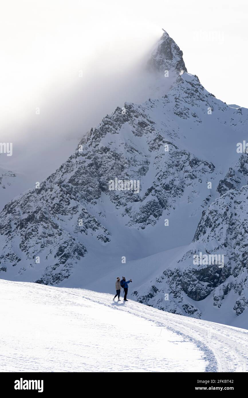 Tourists photographing the snowy peaks during a winter hike, Muottas Muragl, Samedan, Engadine, Graubunden canton, Switzerland, Europe Stock Photo