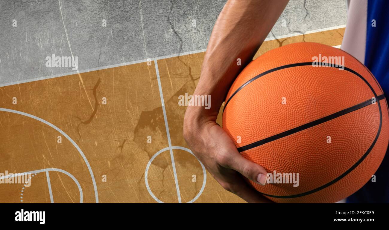 Composition of basketball player holding basketball over basketball ...