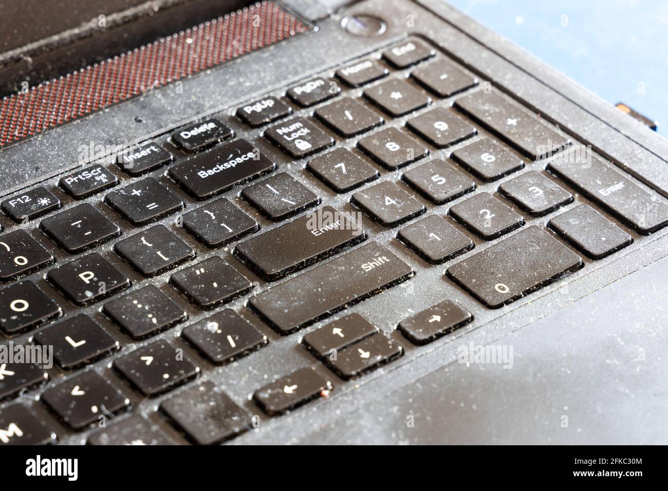 Close-up on dirty and unhygienic computer laptop keyboard, full of dust and particles Stock Photo