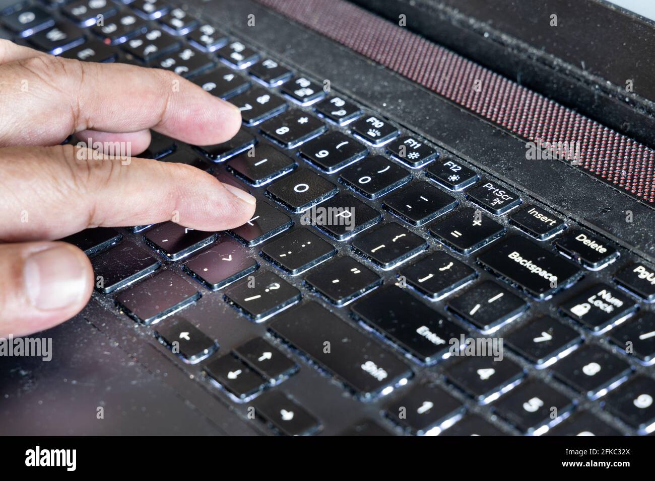 Fingers typing on laptop computer keyboard laced with dusk, particles and is very unhygienic and unhealthy Stock Photo