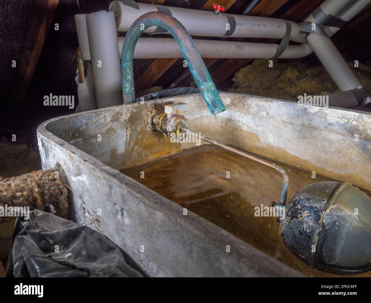 An old and leaking ballcock valve, dripping water into the storage tank /  cistern for a cold water supply, in the loft of a domestic property Stock  Photo - Alamy