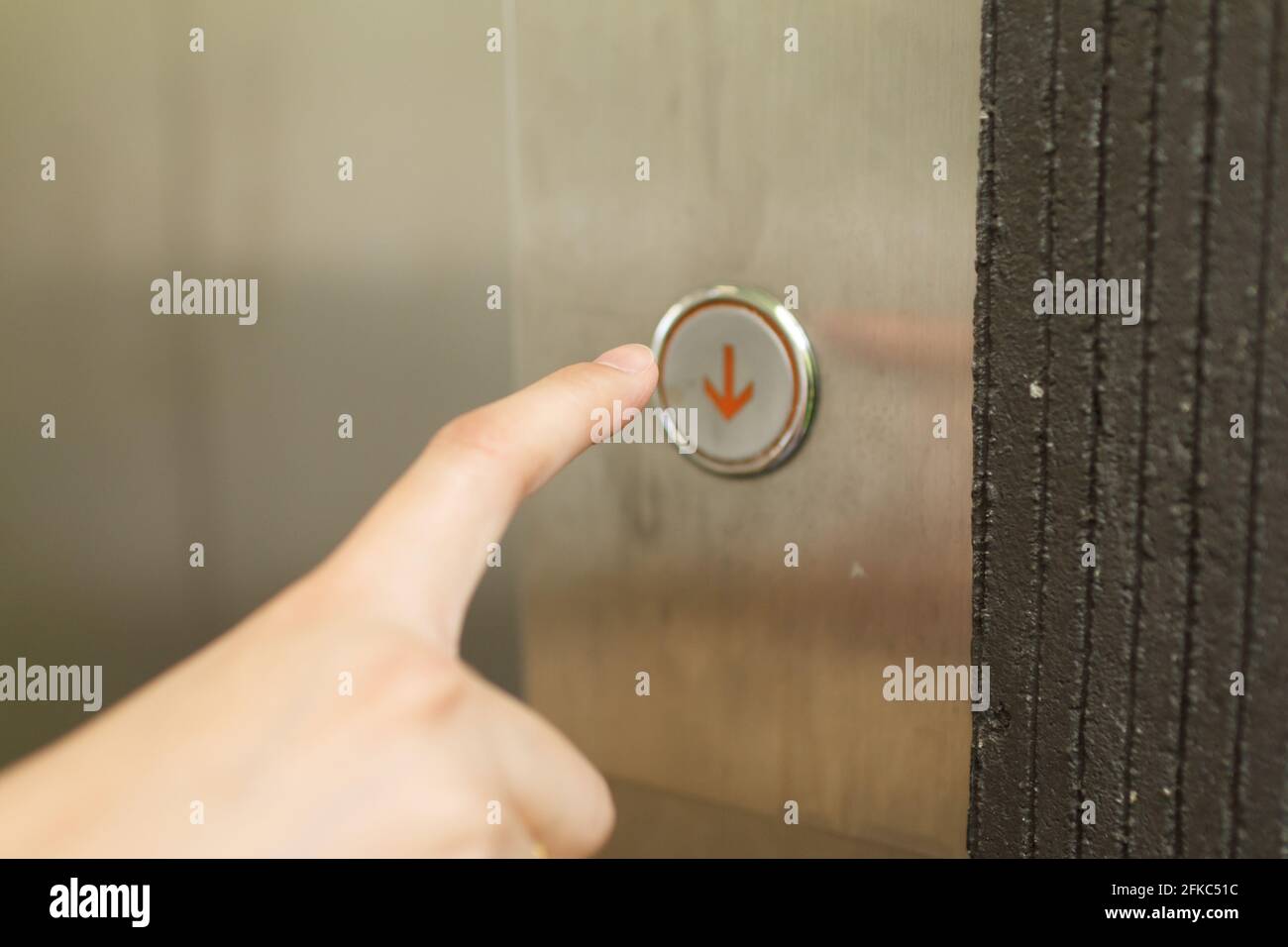Close up of woman hand press of lift. Stock Photo