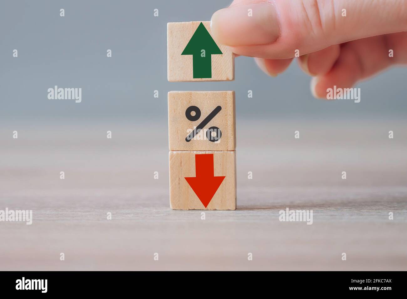 Business growth, success, proces concept. Percentage icon, red arrow going down and hand choosing wood cube with green arrow going up. Interest rates, Stock Photo