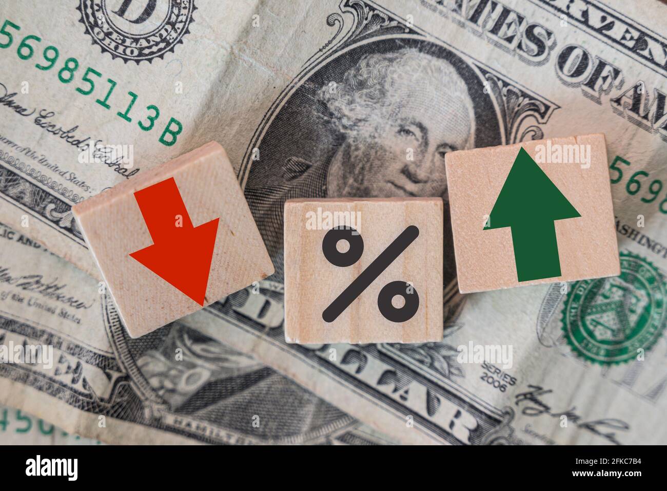 Interest rates,tax, trading, business, financial concept. Percentage icon and arrow symbol on wooden cubes isolated on dollar banknote background Stock Photo