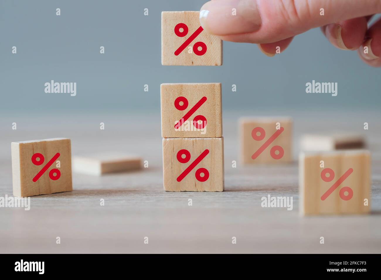 Hand choosing wooden cube block with percentage icon symbol. Interest rate financial and mortgage rates concept. Discount symbol on wooden blocks Stock Photo