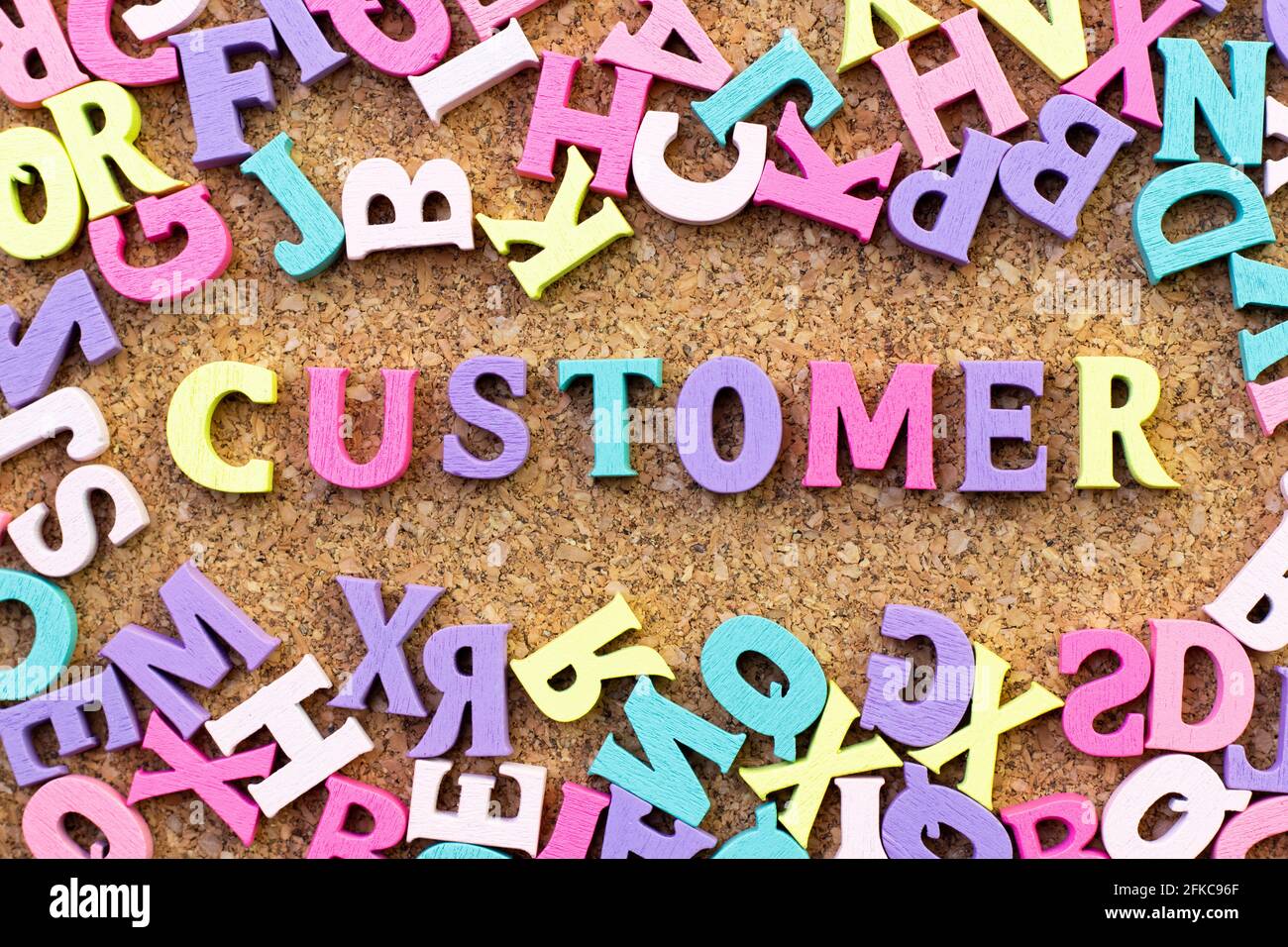 Color alphabet in word customer with another letter as frame on cork