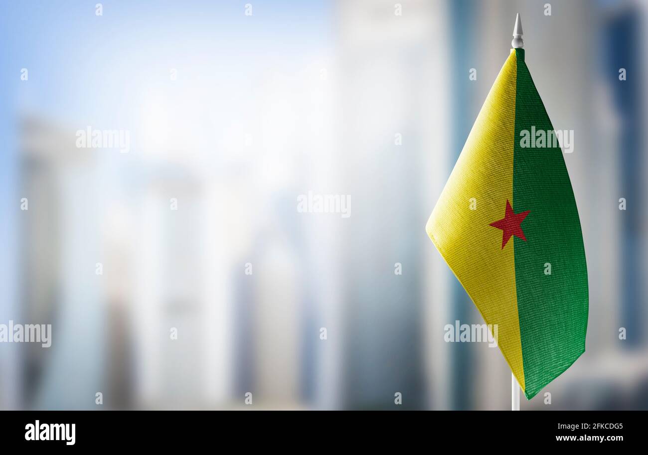 A small flag of French Guiana on the background of a blurred background Stock Photo