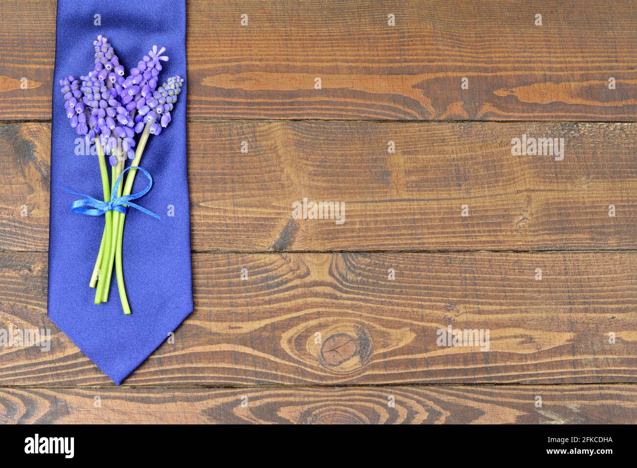 Fathers Day background with blue tie and grape hyacinth flowers Stock Photo