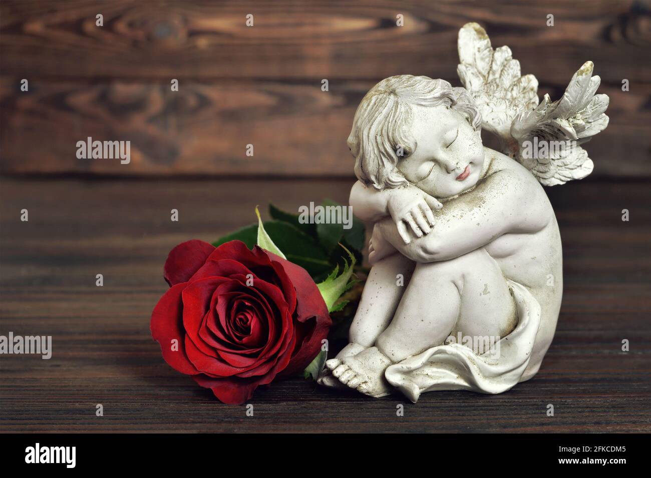 Angel guardian sleeping on wooden background Stock Photo